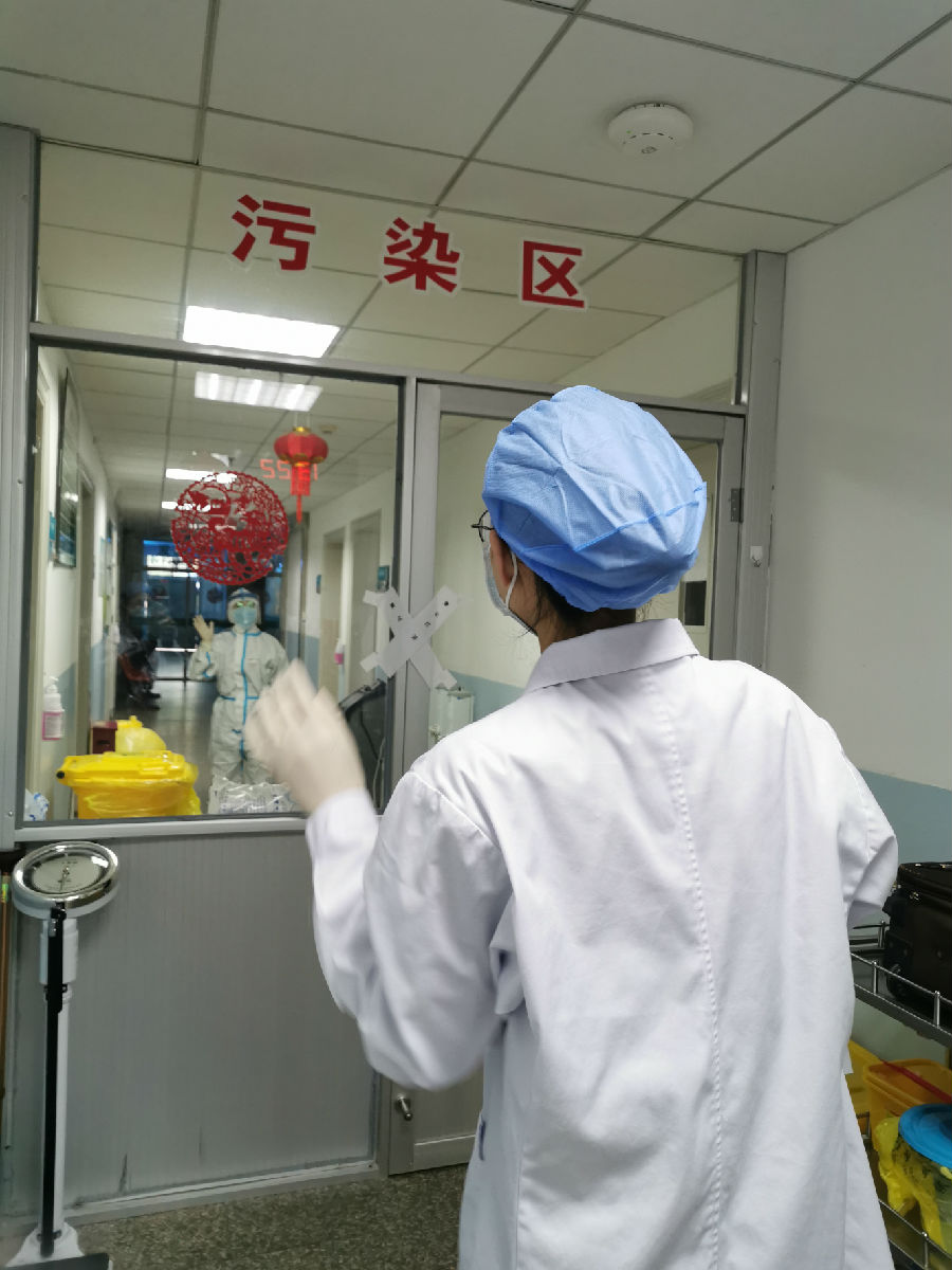 2020年2月4日，工作人员隔着隔离门互相鼓劲